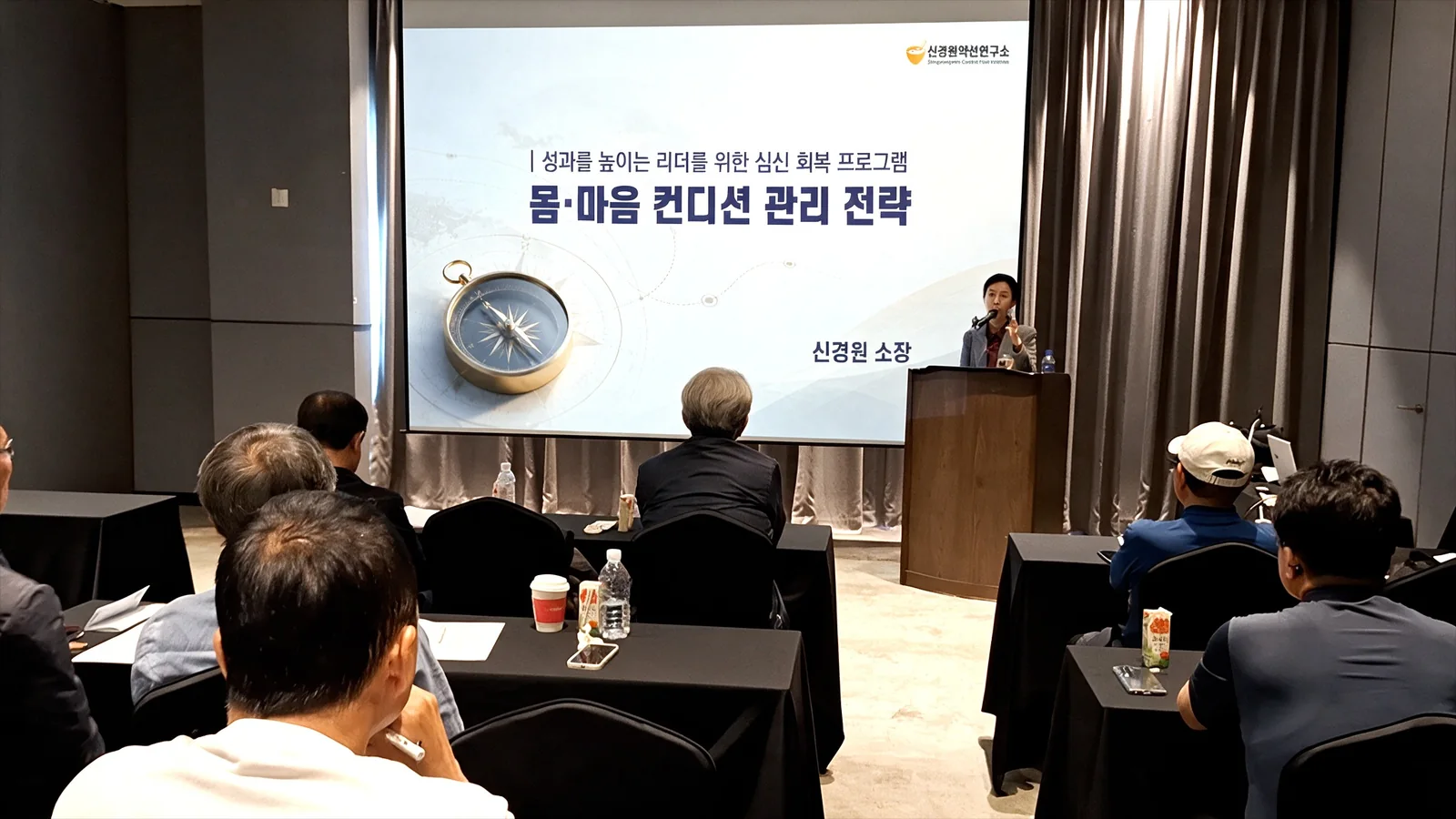 신경원 소장이 손짓으로 설명하고 앞자리의 CEO·임원 참석자들이 강연 화면을 바라보는 모습